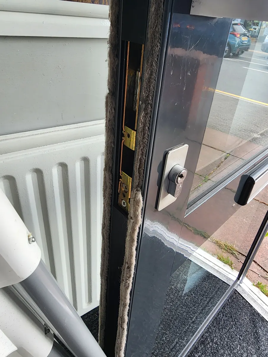 Aluminium shopfront door with a euro cylinder lock.