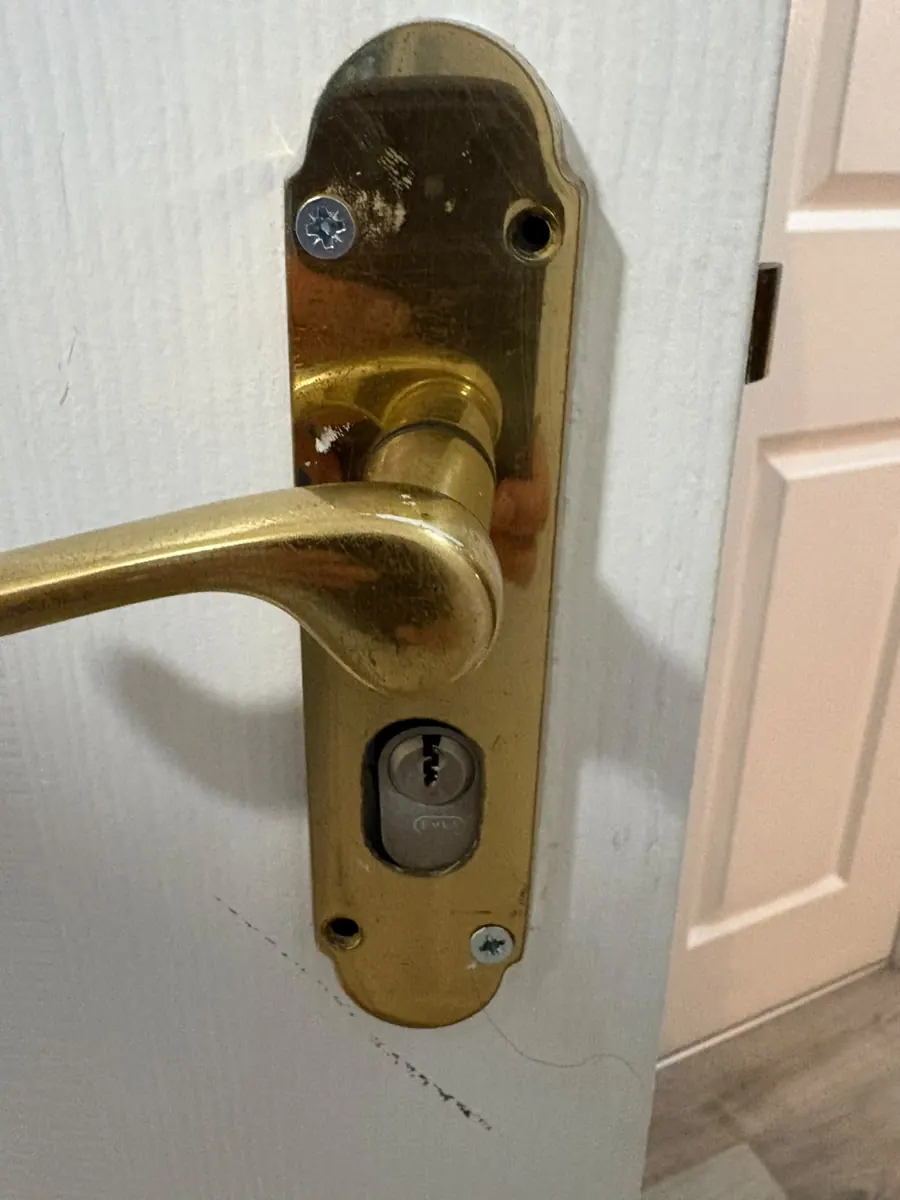 Brass lever handle with a cylinder, on an internal door.
