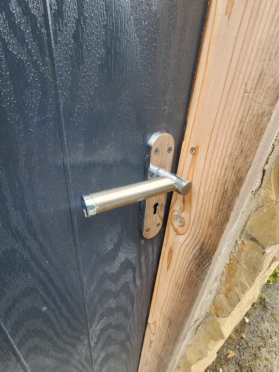 After: a new lever handle fitted to the same door.