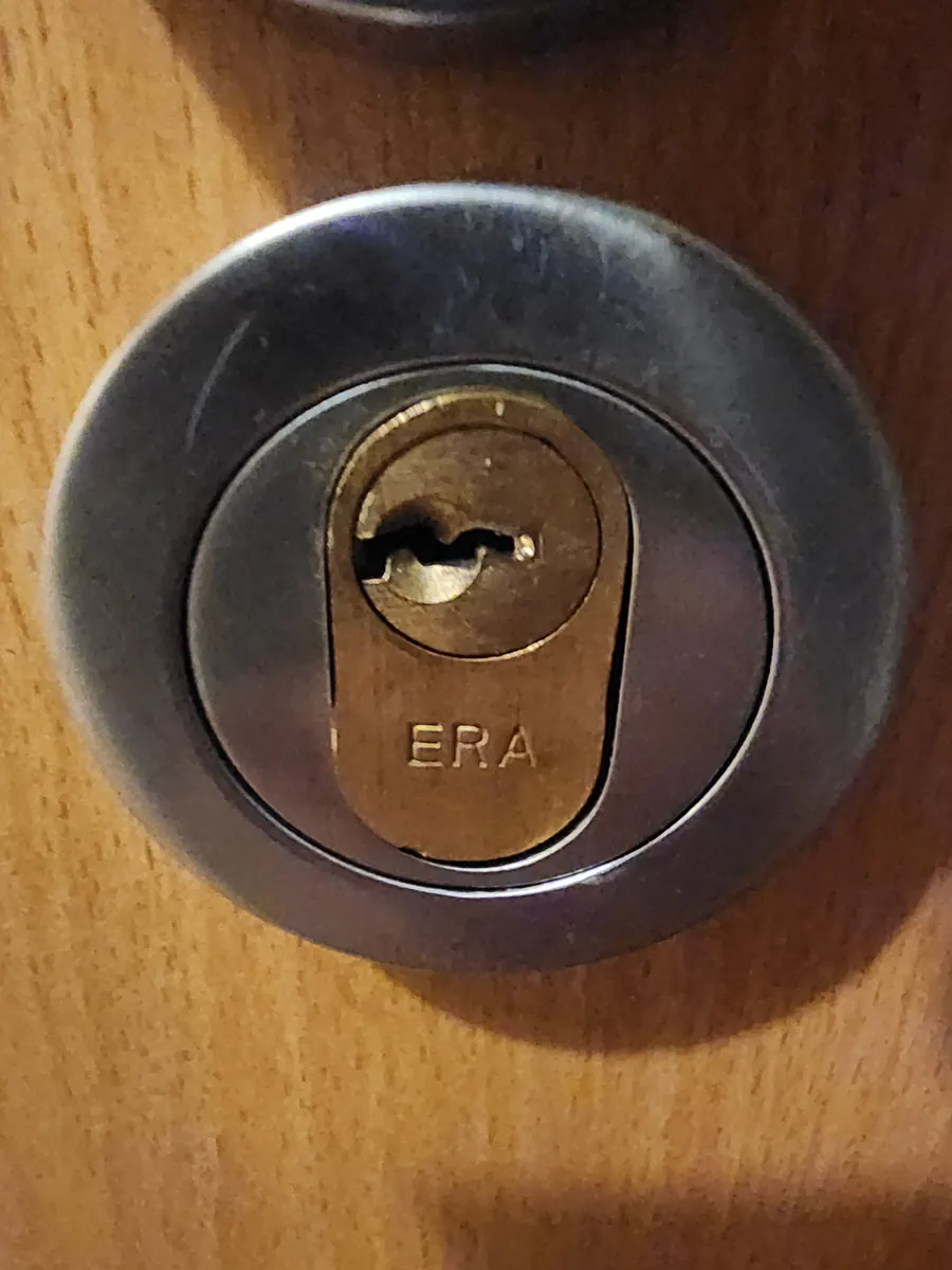 An ERA cylinder lock in a wooden door.