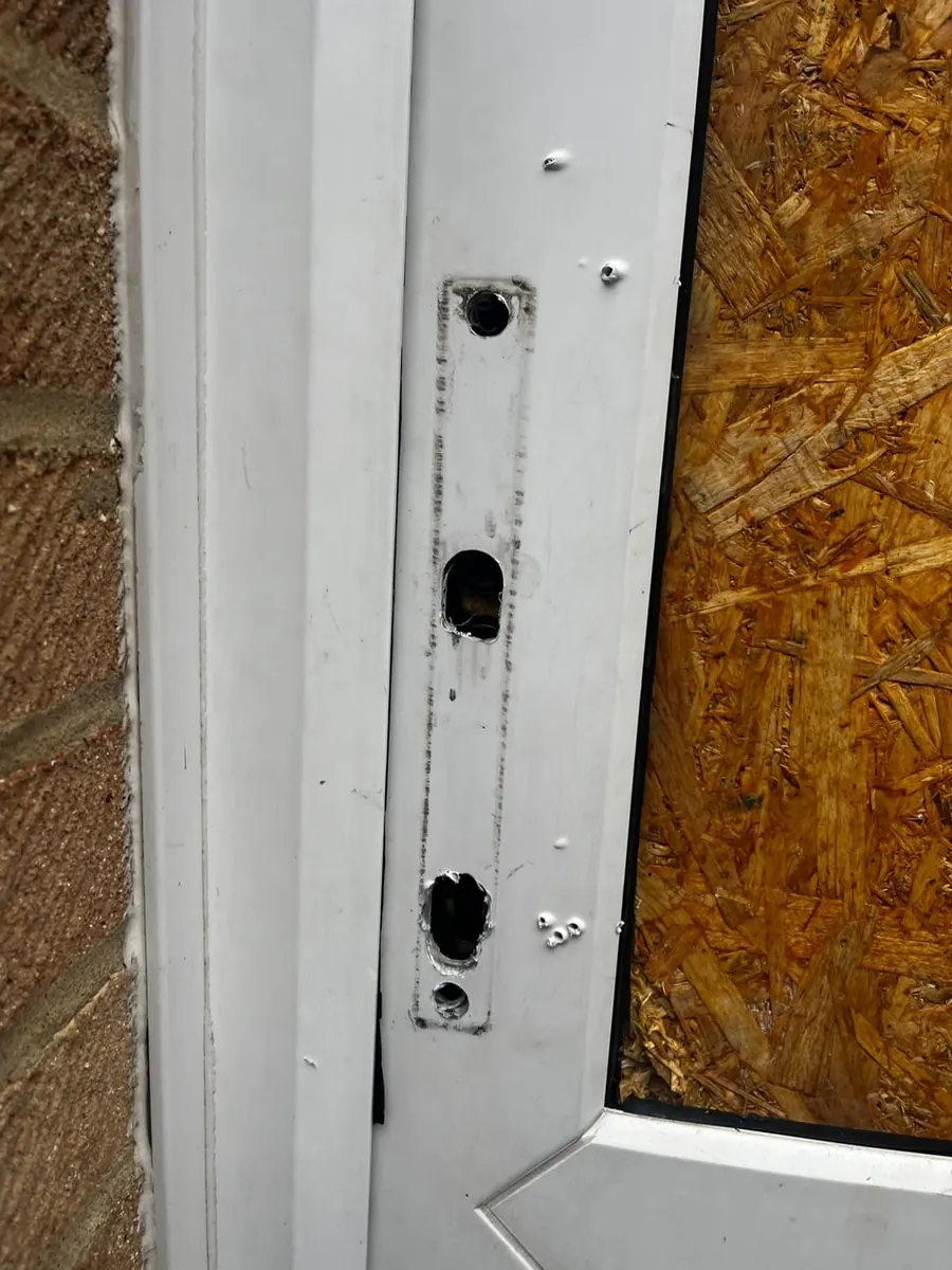 Keeps torn out of a door frame, with a broken panel boarded up.
