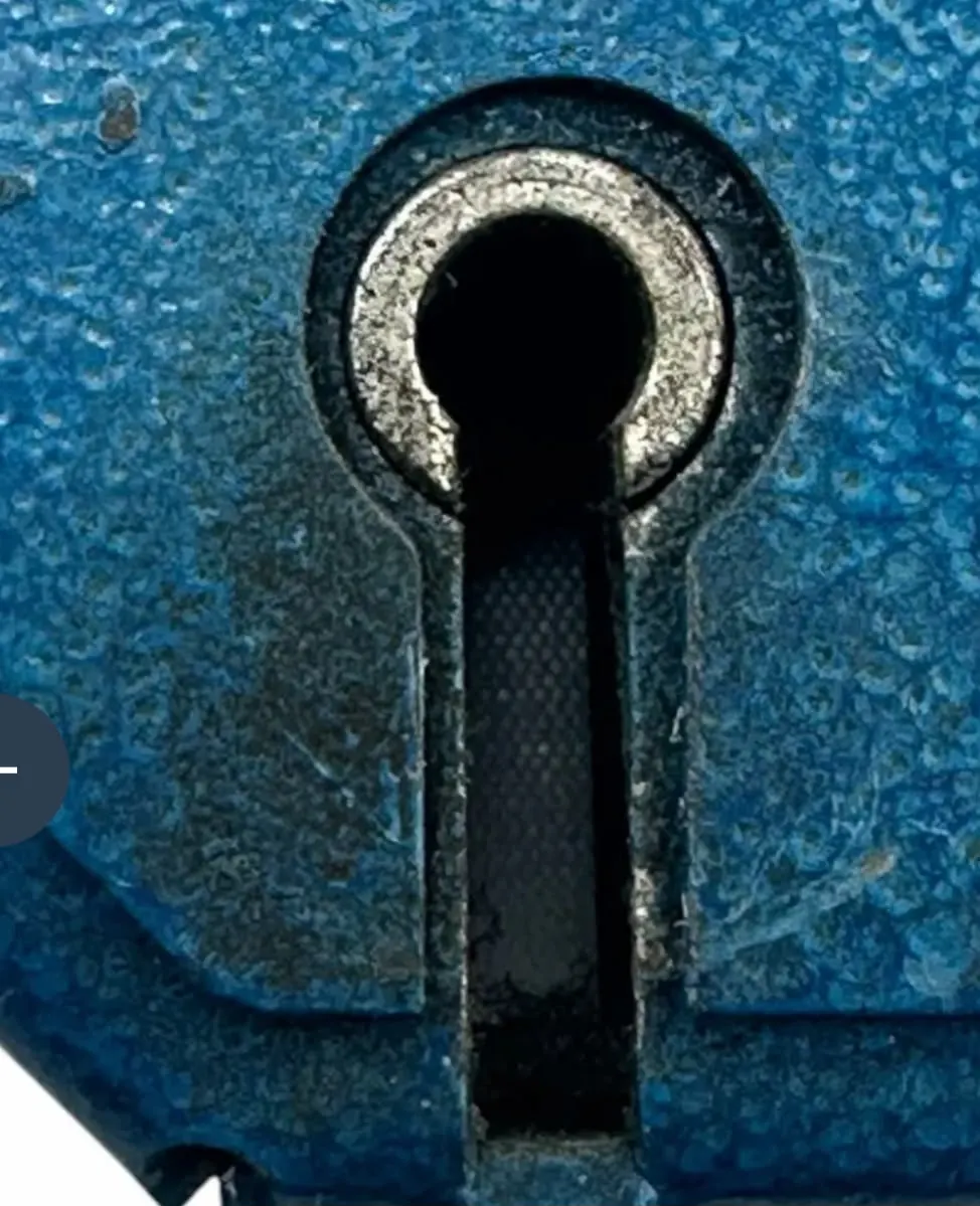 A weathered lock case on an outside door, pitted by years of salt air.